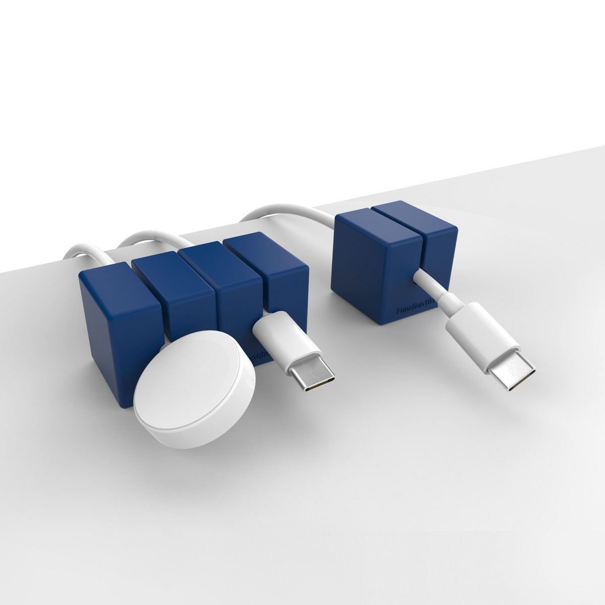 3 CABLE BLOCKS Magnetic and Weighted Cord Organizers in Blue on end of a table.