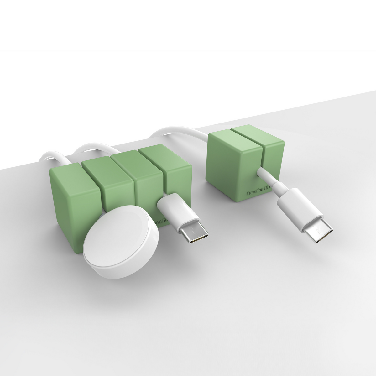 3 CABLE BLOCKS Magnetic and Weighted Cord Organizers in Green on end of a table.