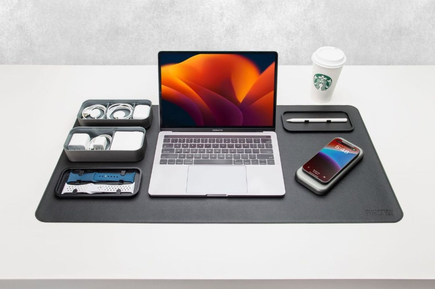 
                  
                    BentoStack Charge with Apple charging cables organized on a desk mat with MacBook Pro
                  
                